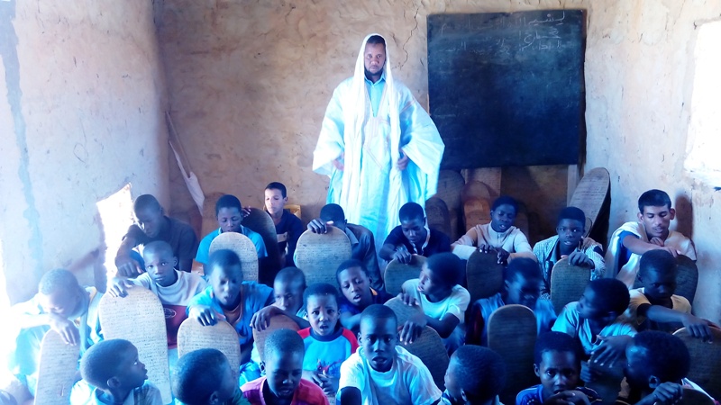 المدرس الداه ولد محمد مع التلاميذ داخل القسم في المنزل المعار للتعاونية